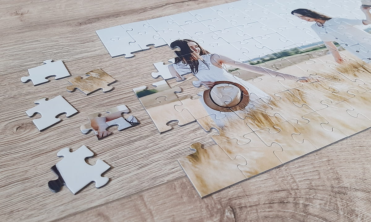 Foto puzzle składające się ze 100 elementów, bez pudełka, leżące na powierzchni stołu.